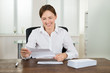© Andrey Popov - Businesswoman Holding Document At Desk