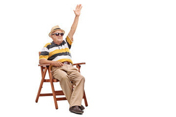 Poster - Senior gentleman sitting in a chair and waving