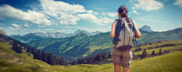 Wall Mural - female hiker admiring view of mountain valley