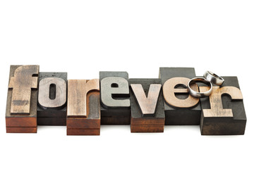 Wall Mural - wedding rings on the word forever written with vintage letterpress printing blocks isolated