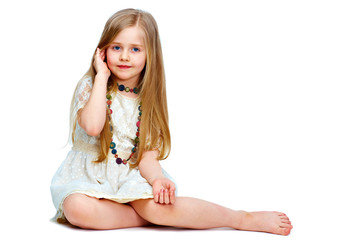 Wall Mural - girl child with long blond hair siting on a floor.fashion portr