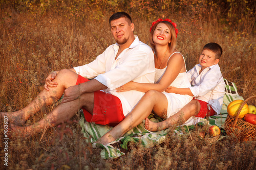 Mom Dad And Son Posing In The Park Sitting On The Plaid Outdoors
