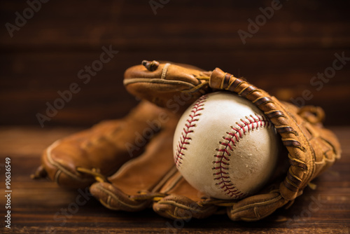 Fotografie, Obraz Leather baseball glove and ball on a wooden bench