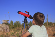 Young Astronomer.a Young Astronomer Studies The Celestial Bodies Through A Telescope While Lying In The Park