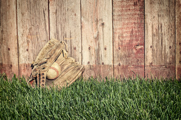 Sticker - Old baseball mitt and ball on grass against wooden fence