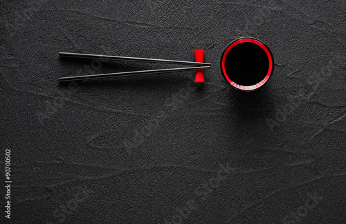 Chopsticks and bowl with soy sauce on black stone background Canvas