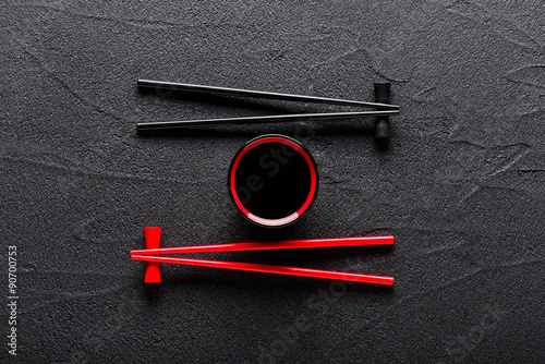 Chopsticks and bowl with soy sauce on black stone background Canvas