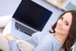 © shefkate - Happy pretty woman using laptop sitting on  sofa