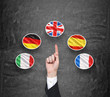 A concept of foreign language studying process. A finger is pointing out the Unites Kingdom flag as a priority in choice of foreign languages. Black chalkboard background.