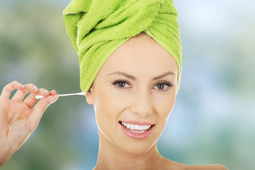 Wall Mural - Woman with cotton bud in ear.