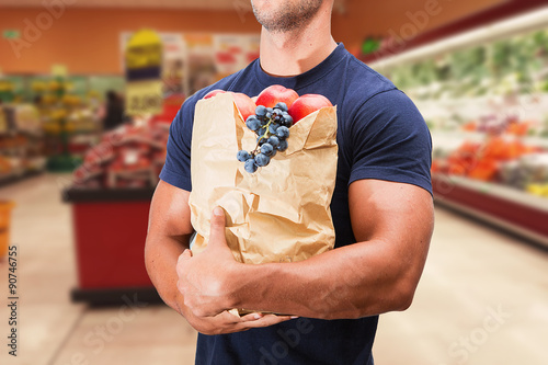 Fotografía uomo fa la spesa in un supermercato con sconti