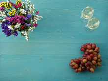 Bouquet Of Wild Flowers, Two Glasses Of Wine And Grapes On A Woo