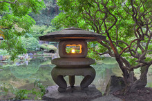 Japanese Stone Lantern By The Creek In Garden