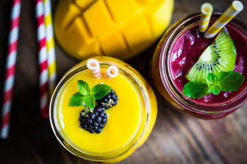 Canvas Print - Colorful two layer smoothies with mango and berries on rustic wo