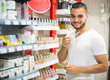 © JackF - Young guy choosing perfume in the shop.