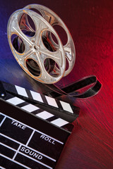 Wall Mural - Cinema clapboard and reel on black stone