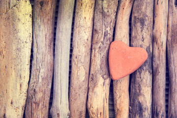 Wall Mural - red stone in the shape of a heart on wood background, vintage process