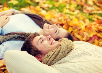 Poster - close up of smiling couple lying in autumn park