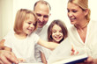 © Syda Productions - happy family reading book at home