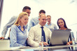 © Syda Productions - smiling business people with laptop in office