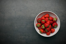 Strawberries In White Bowl On Grey Kitchen Table