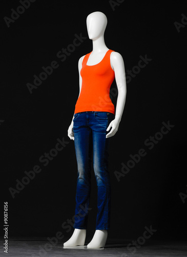 full-length female mannequin orange dressed in jeans on black