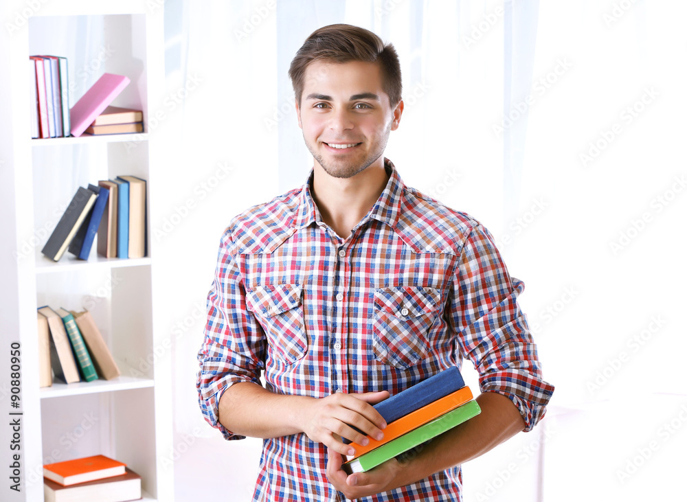 Young man with books in room