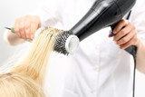 Fototapeta  - Kobieta u fryzjera, fryzjer modeluje włosy na okrągłej szczotce