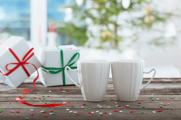 Sticker - two cups with gifts on background Christmas tree