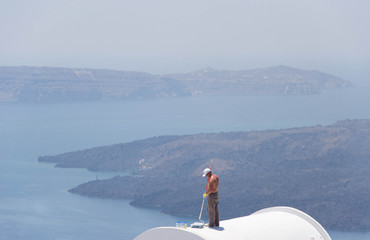 867 - man painting the roofs of the houses of Santorini