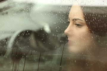 Wall Mural - Sad woman looking through a car window