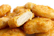 Detail of golden deep-fried battered chicken nuggets with white