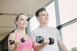 © Syda Productions - smiling young woman with personal trainer in gym