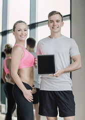 Sticker - smiling young woman with personal trainer in gym