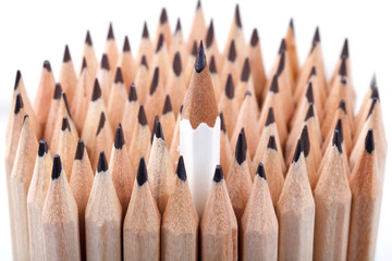 one sharpened white pencil among many ones