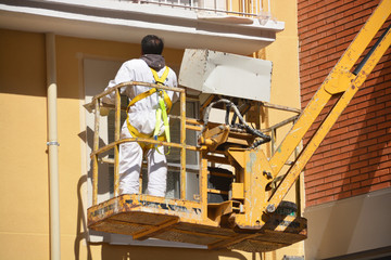 Sticker - pintando una fachada sobre una grua