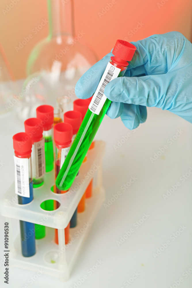 Test tubes with colorful liquid in scientist hand, closeup