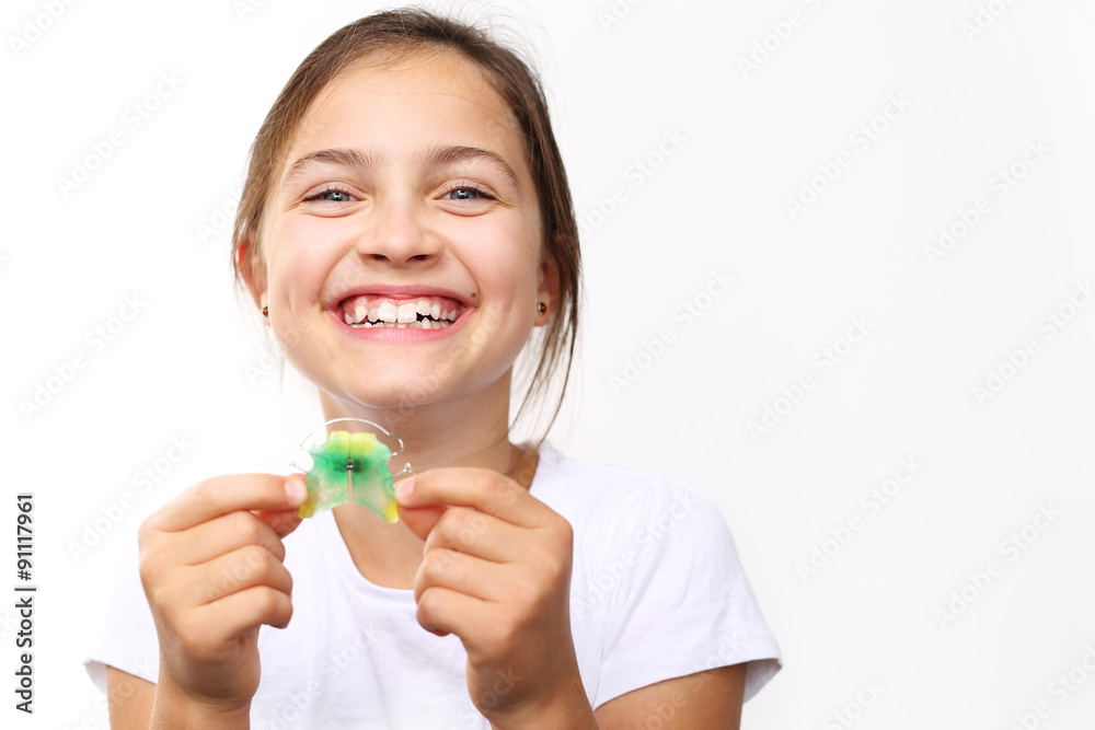 Kolorowy aparat ortodontyczny.Uśmiechnięta dziewczynka z kolorowym aparatem ortodontycznym  - obrazy, fototapety, plakaty 