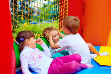 Wall Mural - excited kids having fun on inflatable attraction playground