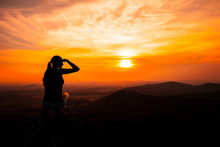 Silhouette Of Woman Watching Sunset And Pointing