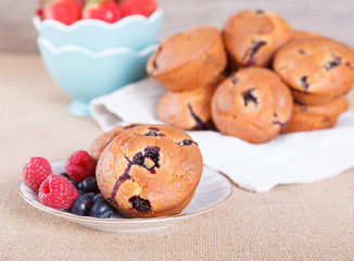 Two blueberry muffins on the plate with berries