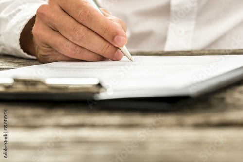 Fotografía Closeup low angle view of male hand signing subscription form, l