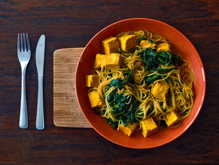 Vegetarian or vegan Indian food with noodles, spinach and tofu 