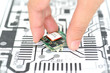 Closeup hand picking electronics device  on schematics background