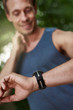 © Flamingo Images - Man Looking at his Watch While Checking Pulse