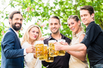 Wall Mural - Freunde oder Kollegen im Biergarten zum Feierabend prosten sich zu