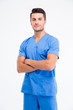 © Drobot Dean - Handsome male doctor standing with arms folded