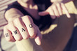 young man with the word swag tattooed in his fist, with a filter