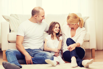 Poster - parents and little girl sitting on floor at home