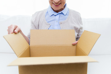 Wall Mural - close up of senior woman with parcel box at home